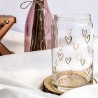 Vaso de cristal con corazones sobre mesa