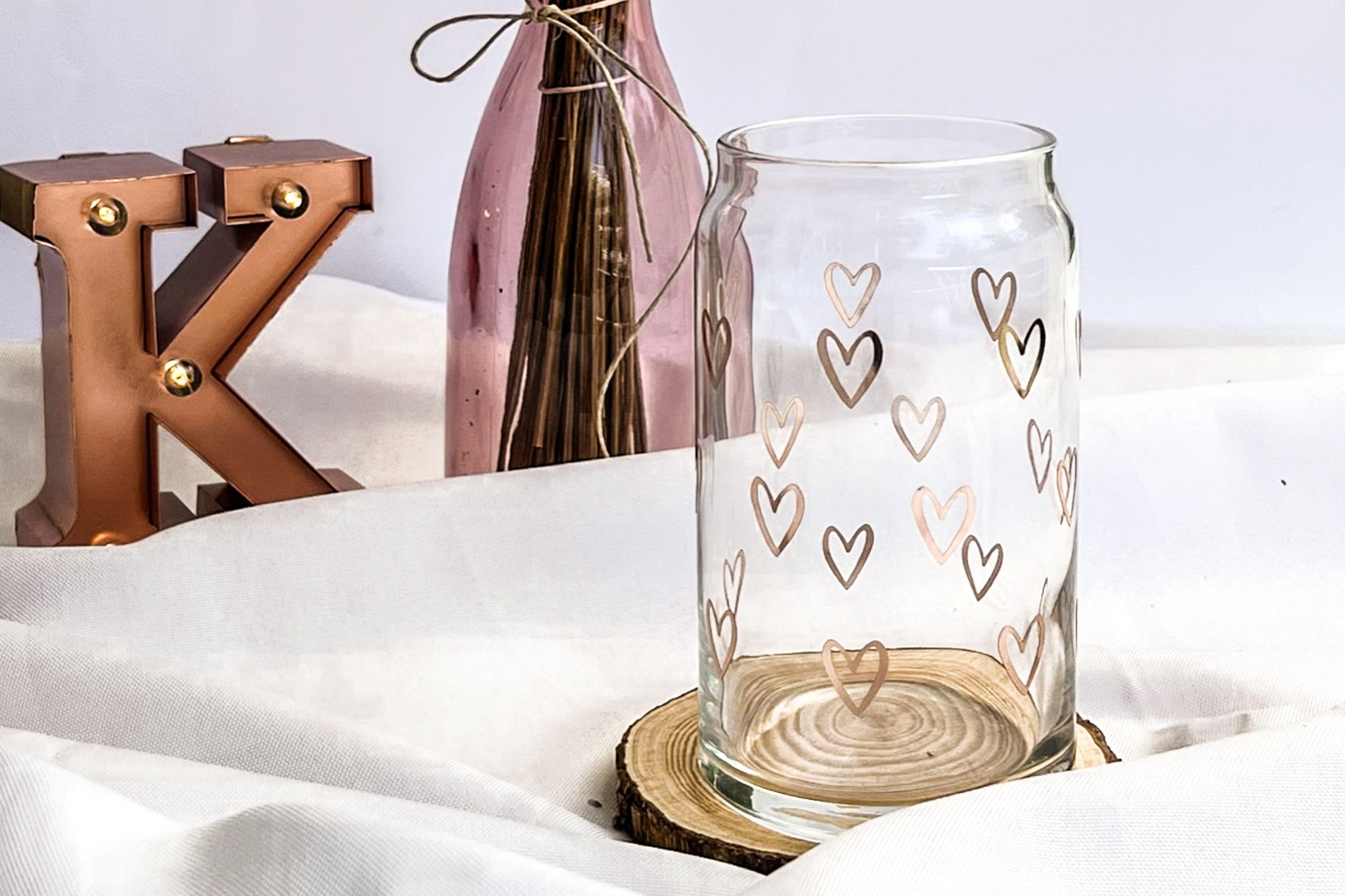 Vaso de cristal con corazones sobre mesa