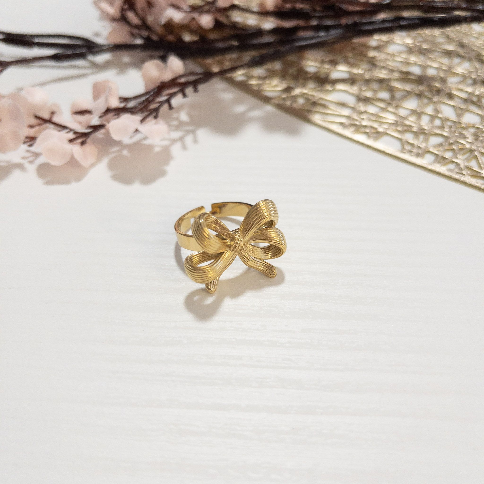 Anillo Lazo (1) Anillo dorado ajustable con diseño de lazo texturizado, estilo romántico.