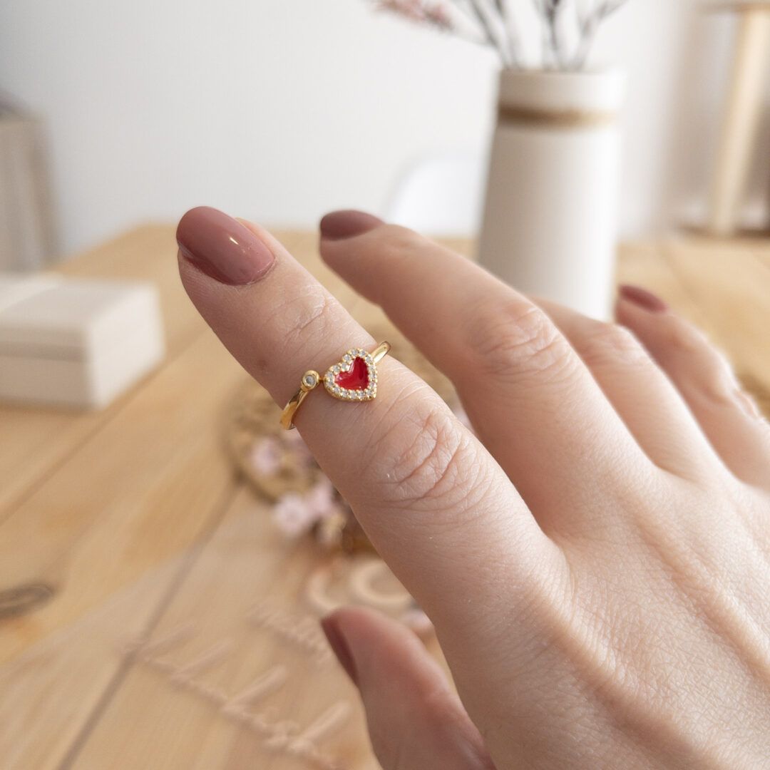 Anillo dorado ajustable con corazón rojo esmaltado y circonitas brillantes.